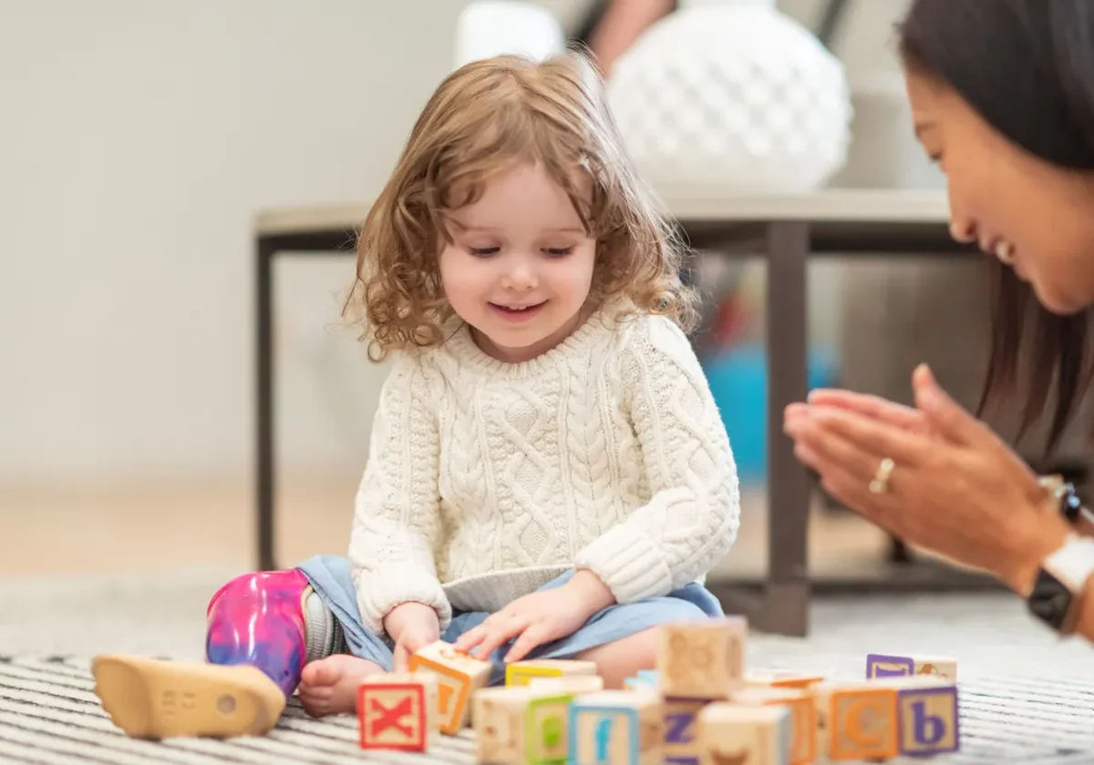 therapist playing on the floor with a toddler